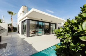 Maison contemporaine avec de grandes baies vitrées donnant sur une terrasse et une piscine